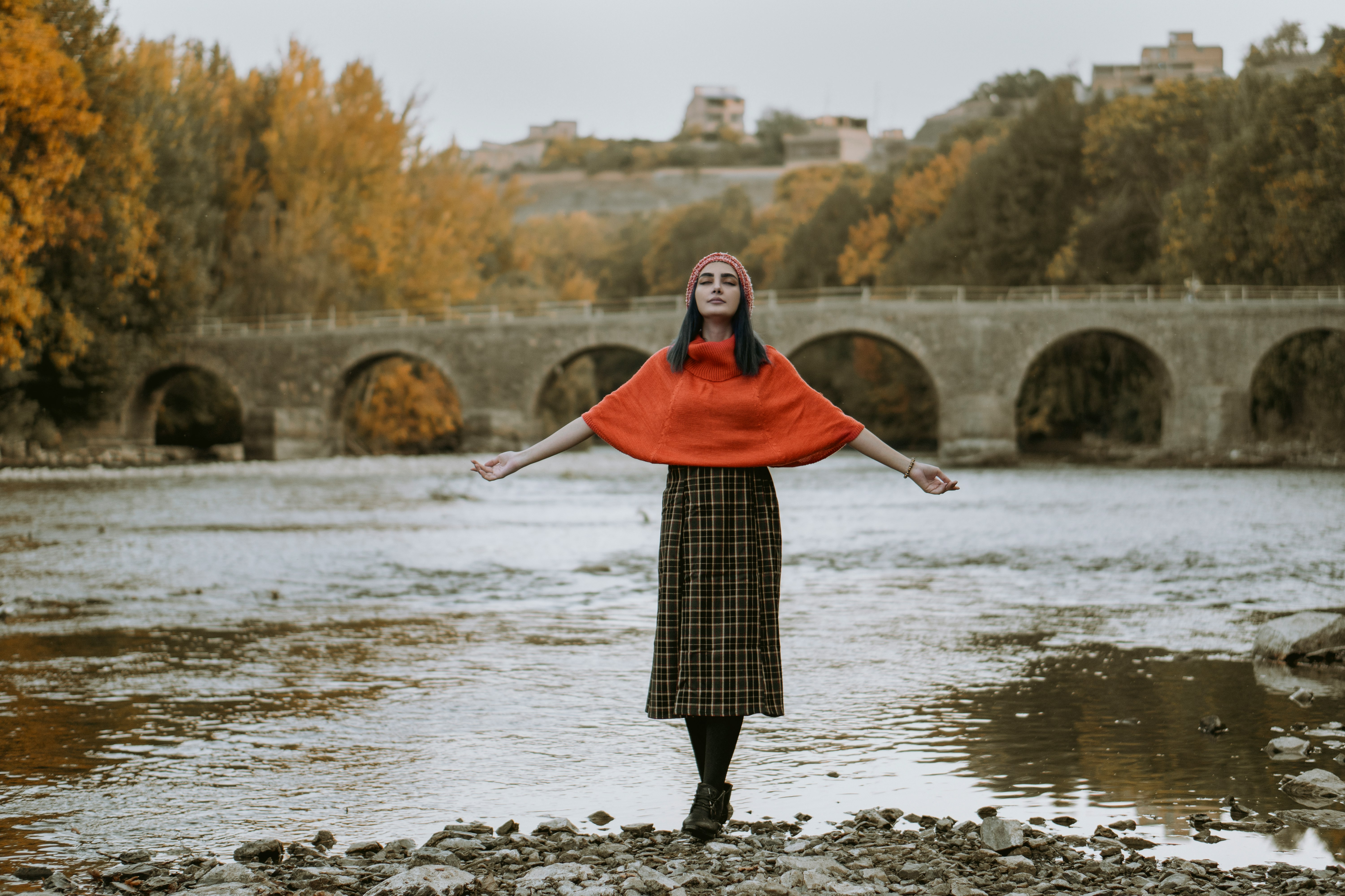 woman in red hijab standing on river during daytime